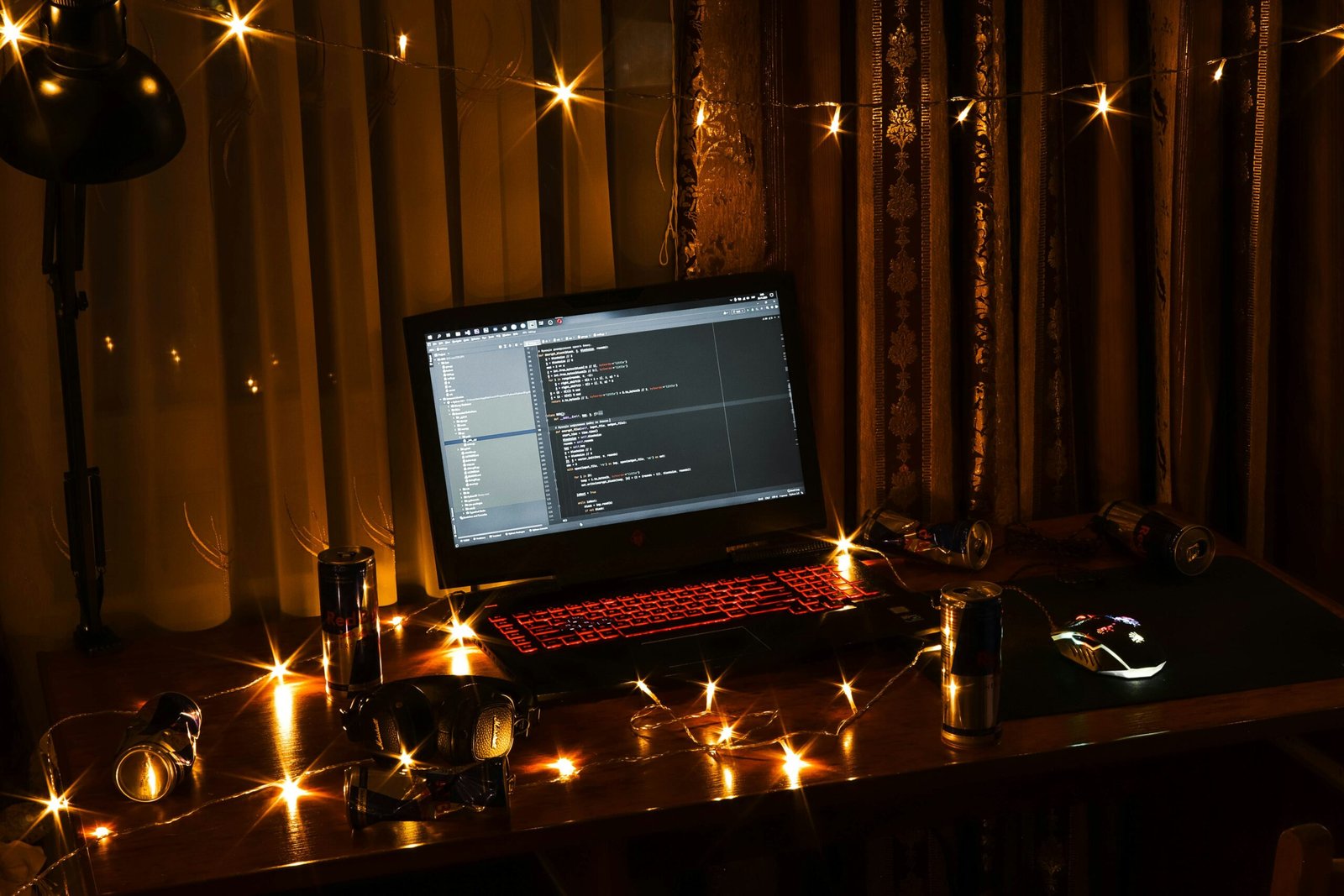 Laptop computer open on a desk with glowing Christmas lights in the background, representing cybersecurity during the holidays